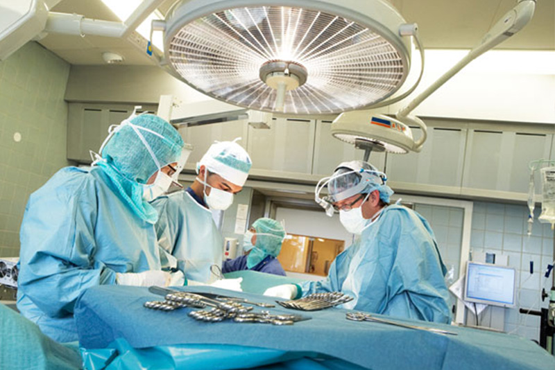Tre kirurger vid operationsbord